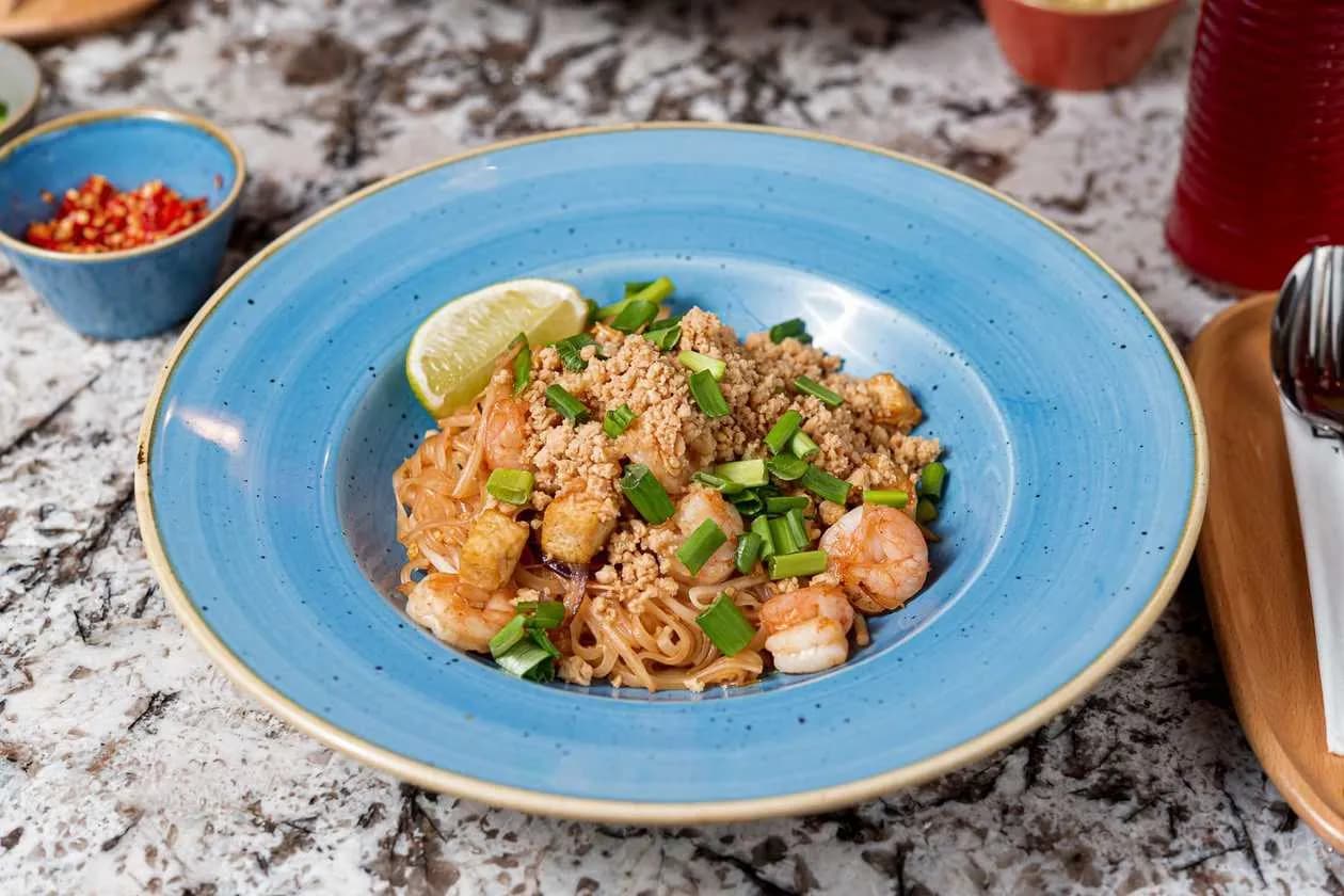 Fried Rice Noodles with Shrimps, Tofu, Red Onion, Sprouts, Egg, Peanuts and Green Onions