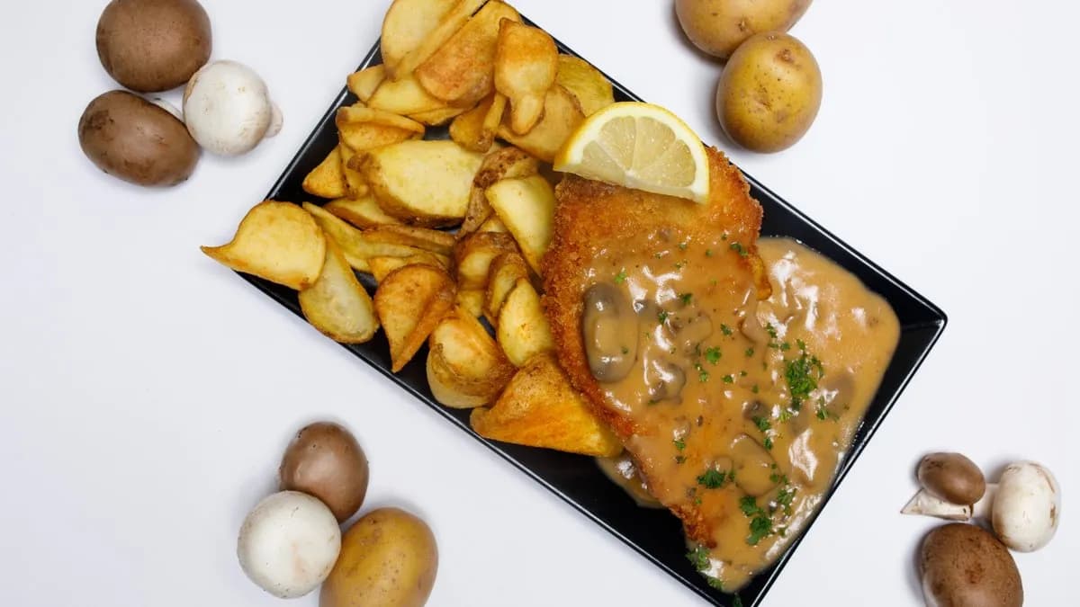 Hähnchenschnitzel Teller mit Pilzrahmsoße und Pommes