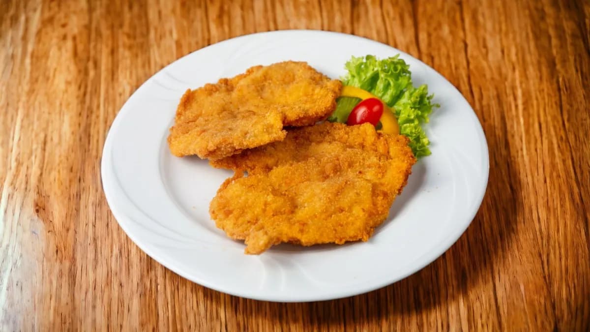 Rántott csirkemell fűszeres burgonyával, hagymakarikával