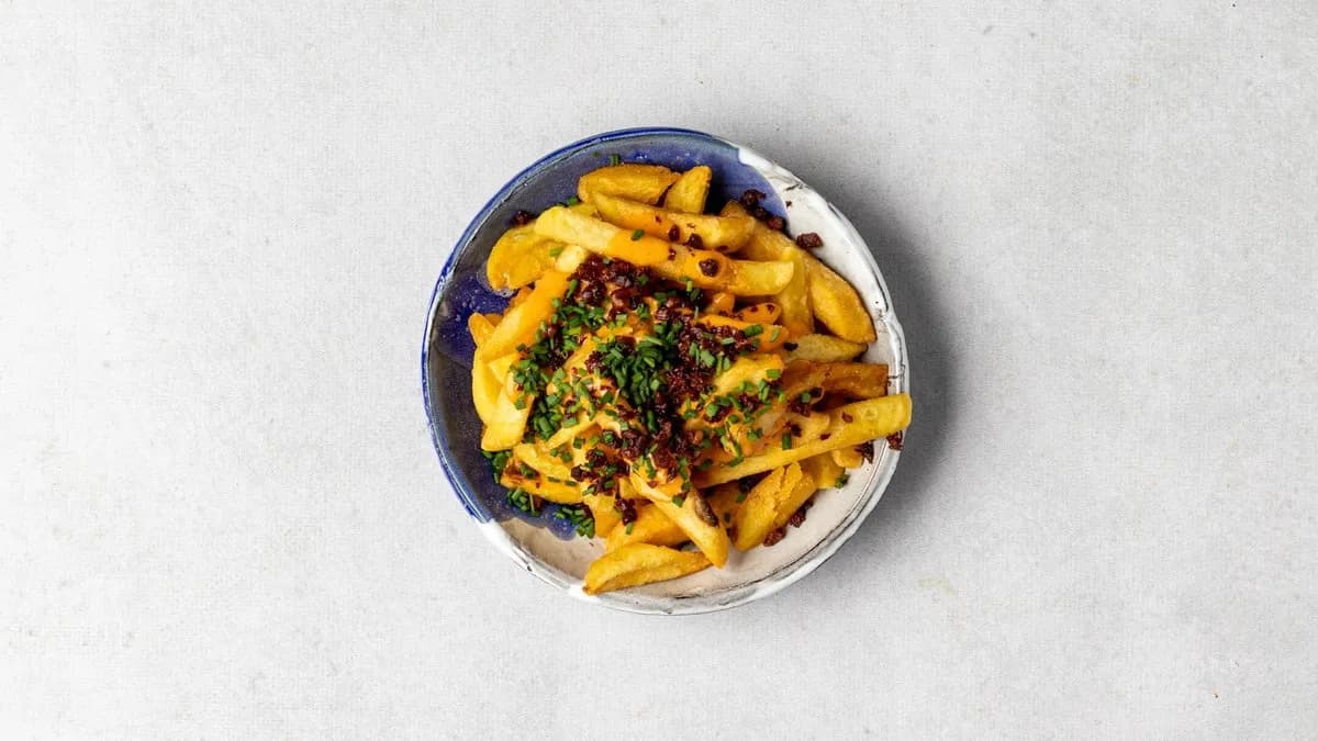 Frytki z sosem serowym, boczkiem i szczypiorkiem