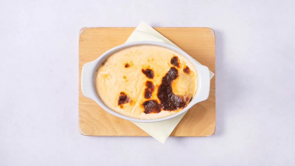 Zapiekany: Dorsz pieczony na szpinaku zapiekany z sosem serowym