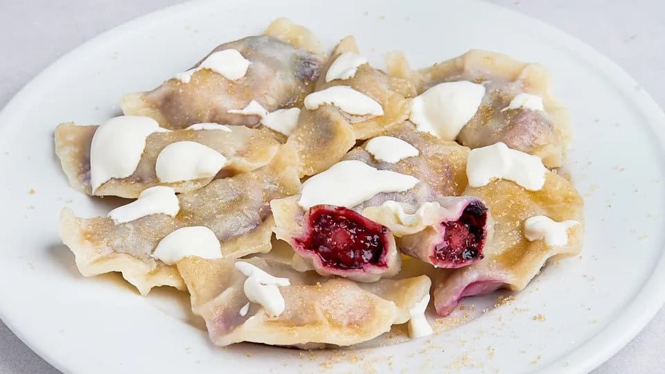 Pierogi z owocami leśnymi ze śmietaną i cukrem