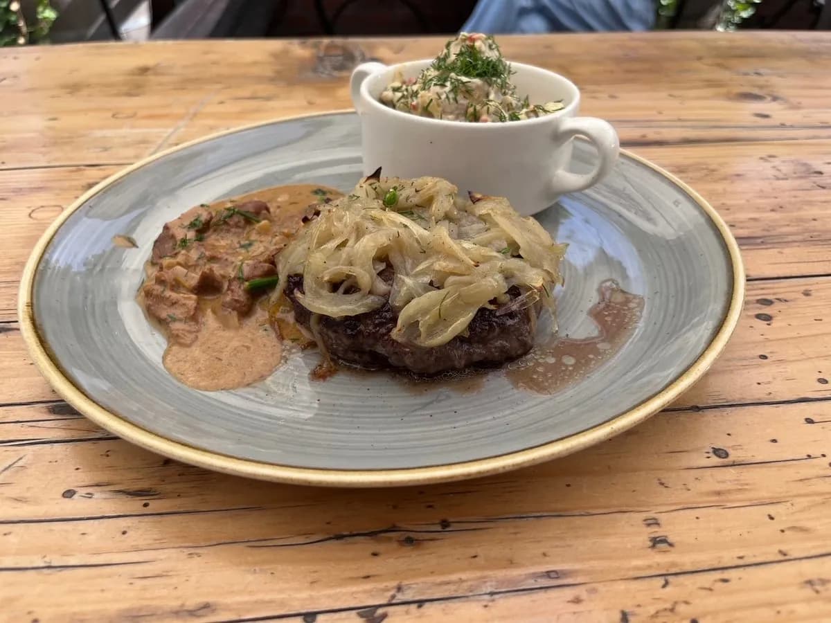 Rumsztyk zapiekany z cebulką podany z sosem kurkowym i sałatką ziemniaczaną