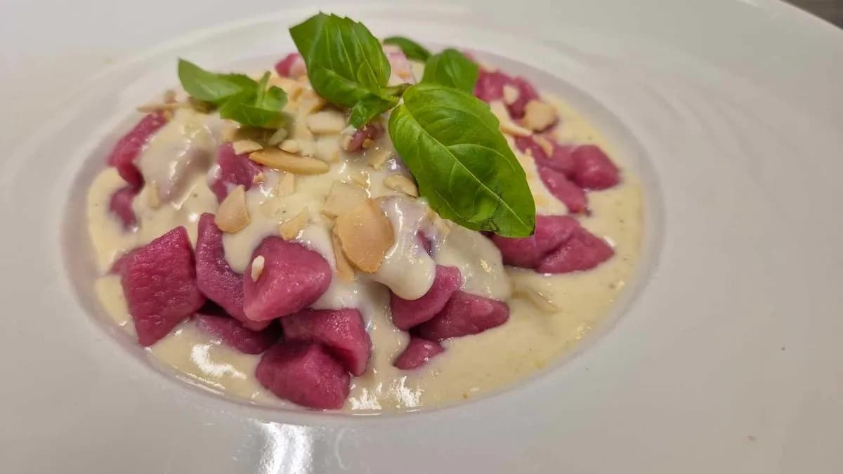 Gnocchi rossi fatti in casa in salsa cremosa di parmigiano con mandorle tostate