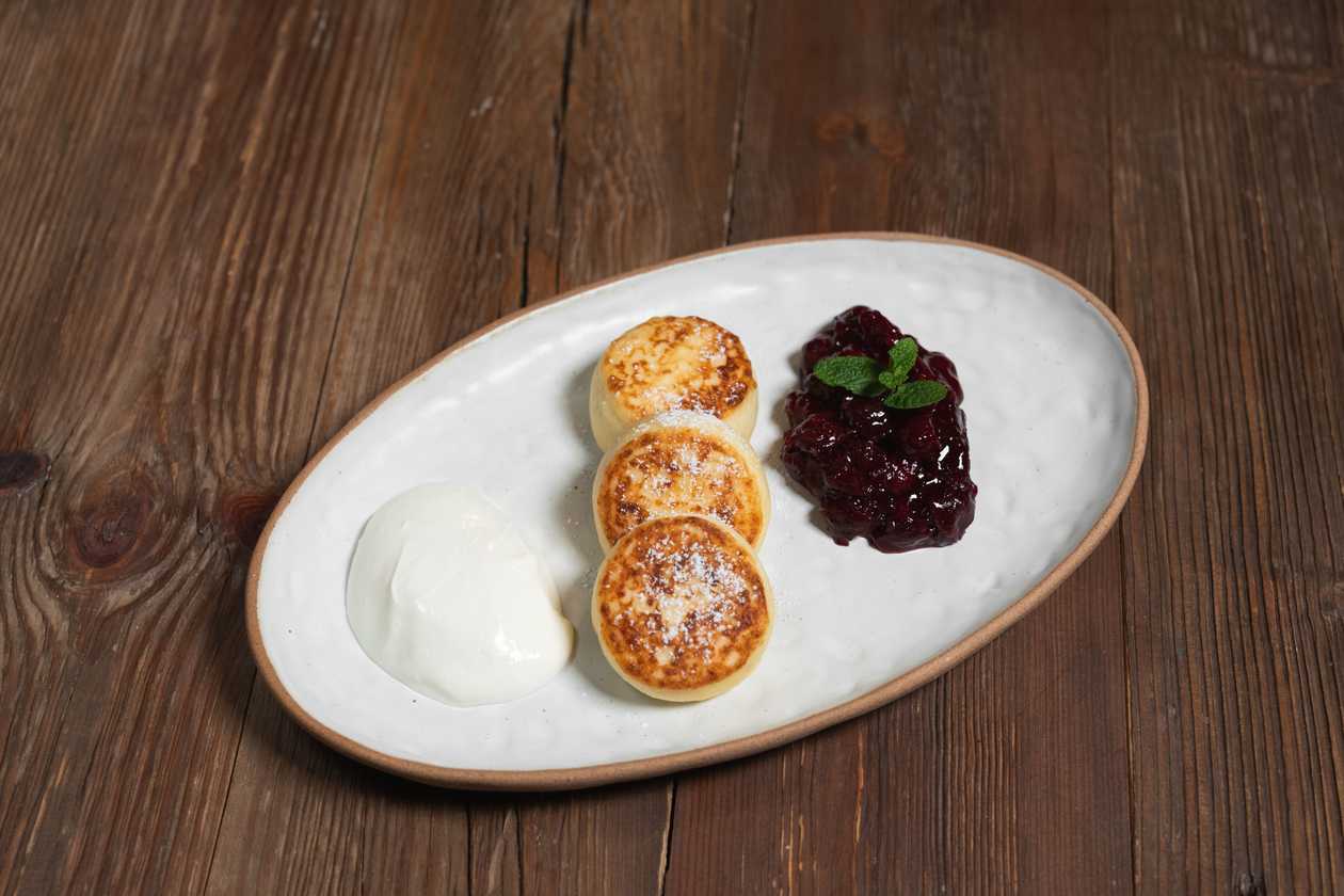 Cottage cheese pancakes with cherry sause and cream