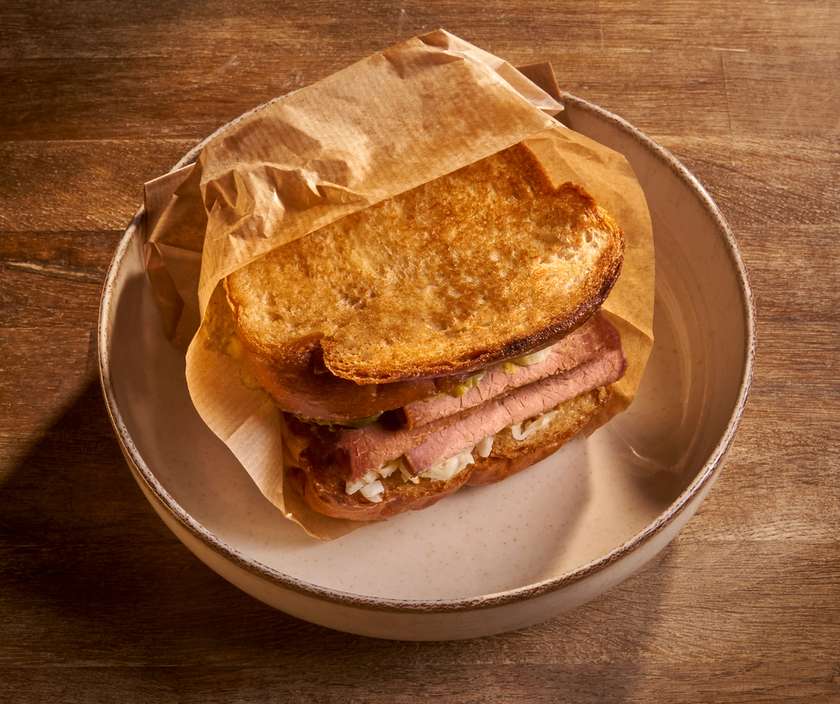 Roast beef sandwich with pickled cucumber, mustard, and coleslaw salad
