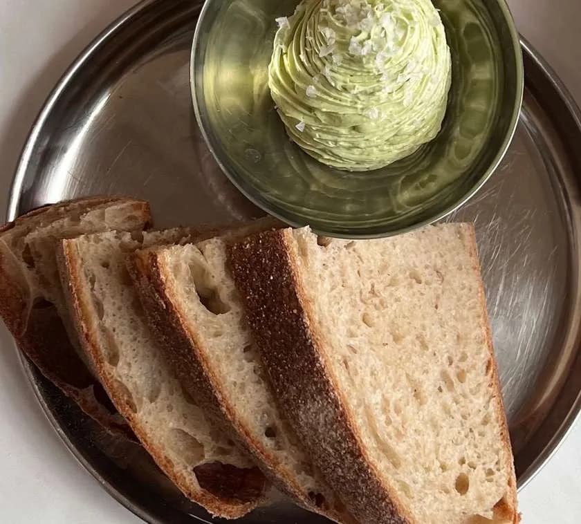 +kromki chleba z zielonym ubitym masłem i płatkami soli