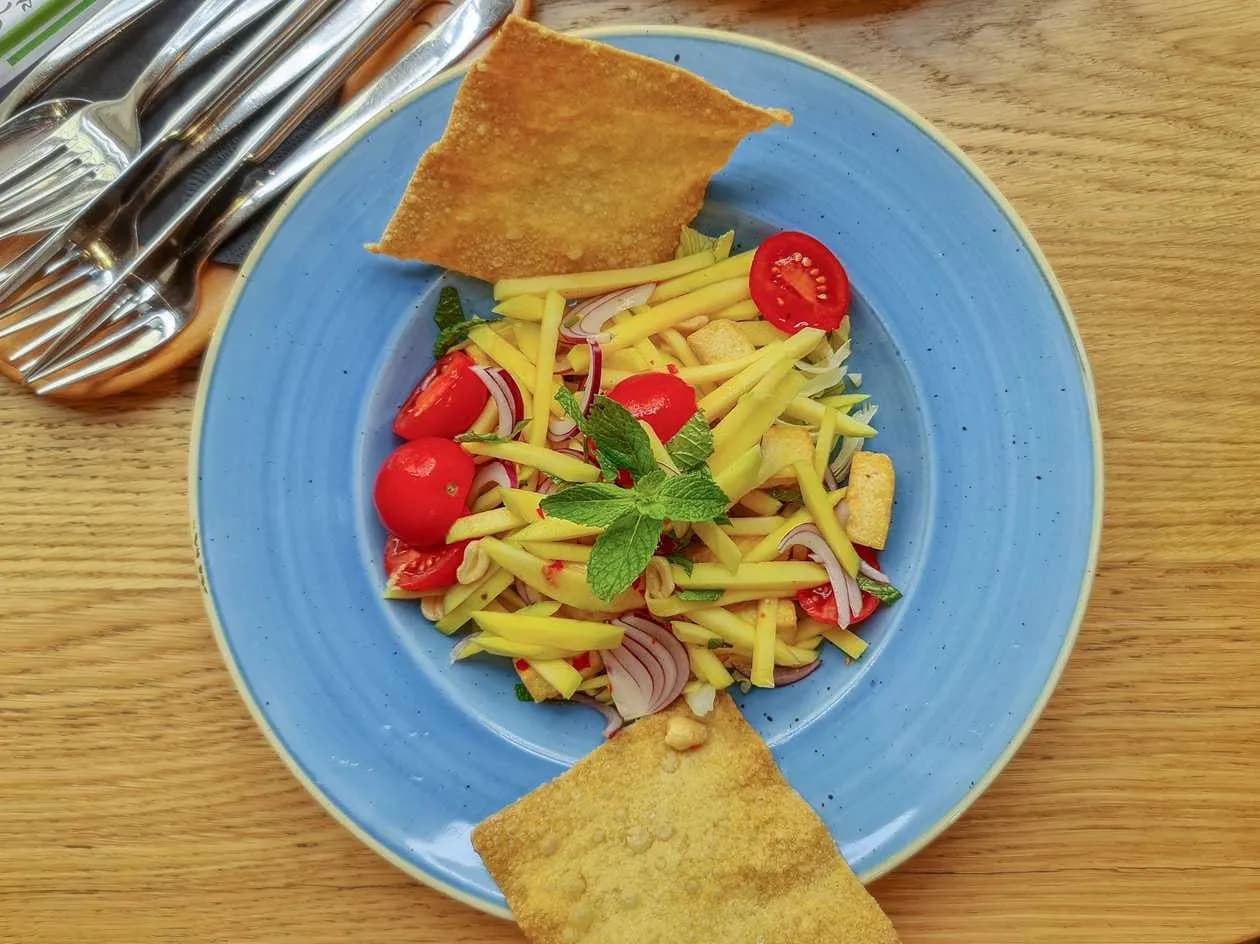 Shrimps and Mango Salad with Iceberg Lettuce, Red Onion, Mint, Cherry Tomatoes, Peanuts and Chili Dressing