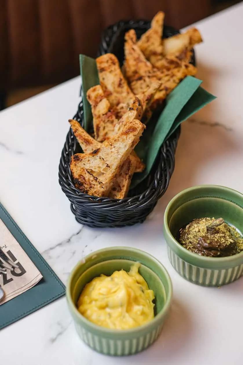 Kosz domowego pieczywa z masłami smakowymi