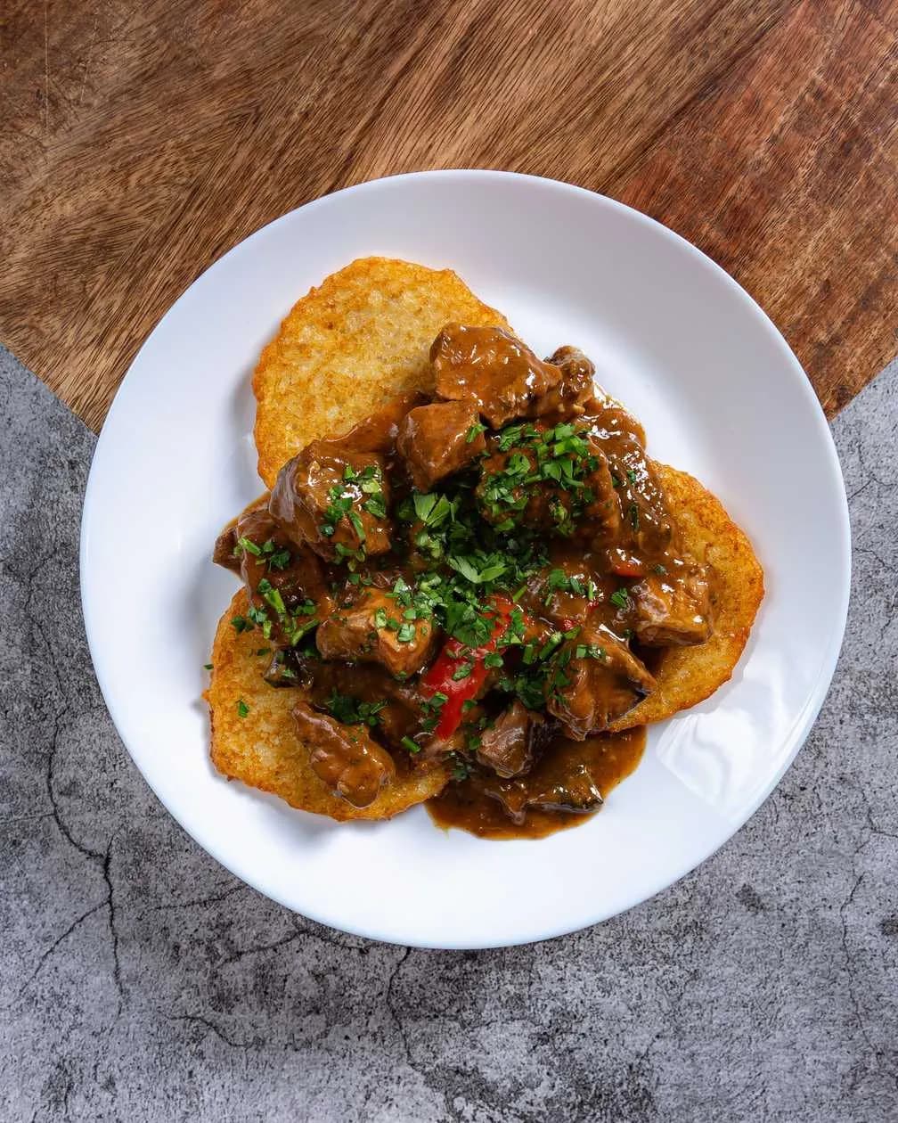 Potato pancakes with goulash, salad