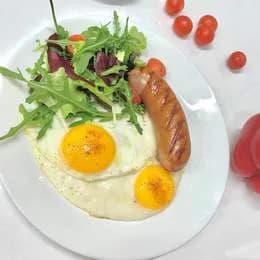 Dwa jajka sadzone z kiełbasą i sałatką