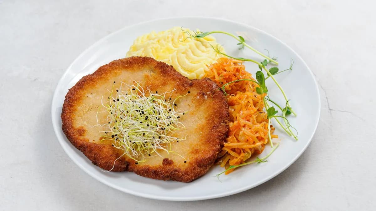Kotlet schabowy z ziemniakami i surówką.