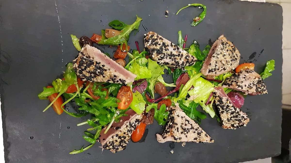 Tonno al sesamo nero con olive, pomodorini, pomodori secchi e capperi alla medit