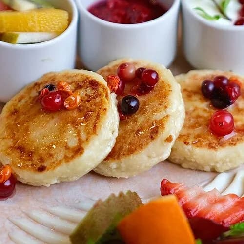 Сырники со сметаной, фруктами и перетёртой ягодой