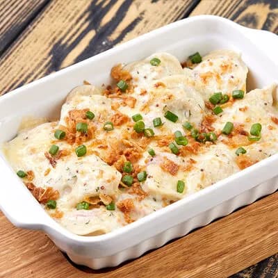 Ассорти из пельменей, запеченное под соусом с горчицей и беконом