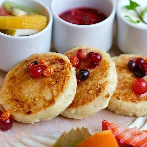 Сырники со сметаной, фруктами и перетёртой ягодой