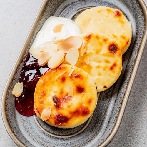 Сырники со сметаной и соусом из вишни