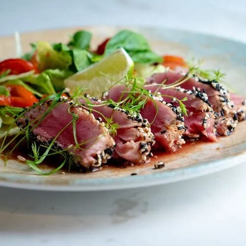 Тунец татаки в кунжуте со свежей зеленью и имбирной заправкой