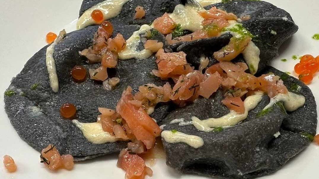 Ravioli al nero di seppia fatti a mano ripieni di salmone fresco